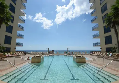 a swimming pool with the ocean in the background at Origin at Seahaven 423 in Panama City Beach
