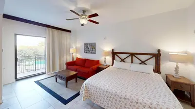 a bedroom with a bed and a red chair at Origin at Seahaven 423 in Panama City Beach
