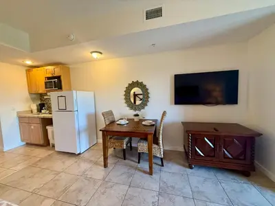 a kitchen with a table and a white refrigerator at Origin at Seahaven 423 in Panama City Beach