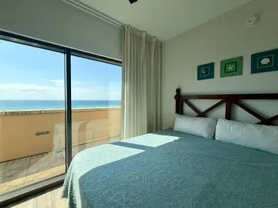 a bedroom with a bed and a view of the ocean at Origin at Seahaven 402 in Panama City Beach
