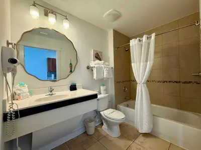 a bathroom with a sink and a toilet and a mirror at Origin at Seahaven 402 in Panama City Beach