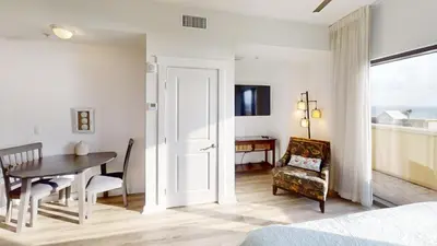 a bedroom with a table and a dining room at Origin at Seahaven 402 in Panama City Beach