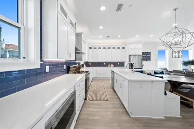 a kitchen with white cabinets and a blue tile floor at Joy by the Sea l Private heatable pool l Beach Front l Family Activities nearby in Panama City Beach