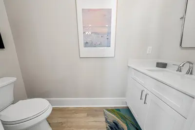 a white bathroom with a toilet and a sink at Joy by the Sea l Private heatable pool l Beach Front l Family Activities nearby in Panama City Beach