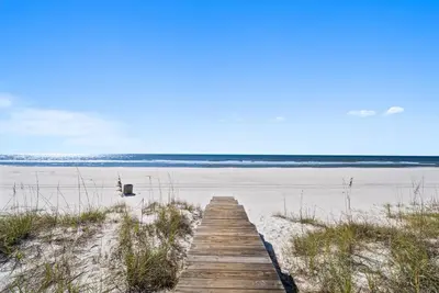 a wooden boardwalk leading to the beach at Joy by the Sea l Private heatable pool l Beach Front l Family Activities nearby in Panama City Beach