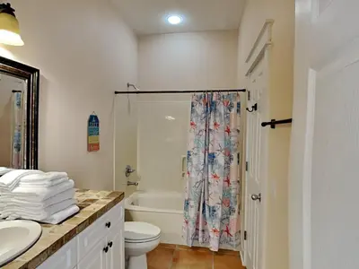 a bathroom with a shower curtain and a toilet at The Mermaid in Rosemary Beach