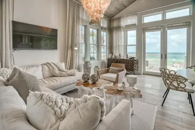 a living room with white furniture and a view of the ocean at Love Shack in Inlet Beach
