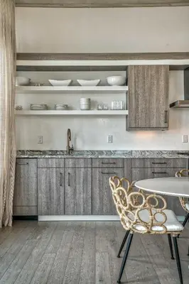 a kitchen with wooden cabinets and a table and a chair at Love Shack in Inlet Beach