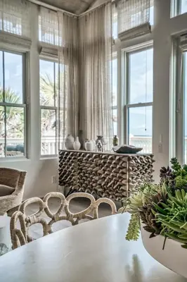 a dining room with a table and chairs and windows at Love Shack in Inlet Beach