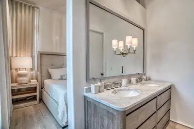 a bathroom with a sink and a mirror and a bed at Love Shack in Inlet Beach