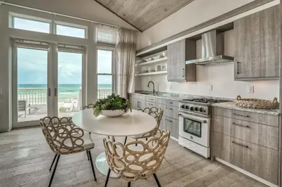 a kitchen with a table and chairs and the ocean at Love Shack in Inlet Beach