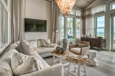 a living room with white furniture and a chandelier at Love Shack in Inlet Beach