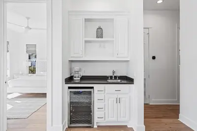 a kitchen with white cabinets and a sink at Pompano In Paradise in Inlet Beach