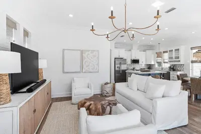 a living room with white furniture and a chandelier at Pompano In Paradise in Inlet Beach
