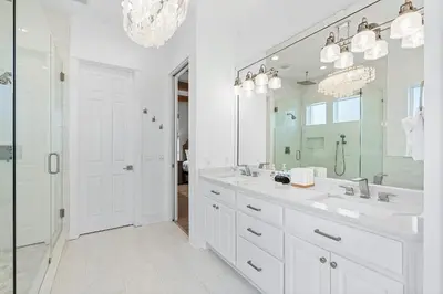 a white bathroom with two sinks and a large mirror at Pompano In Paradise in Inlet Beach