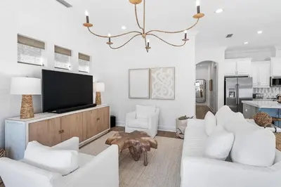 a living room with white furniture and a flat screen tv at Pompano In Paradise in Inlet Beach