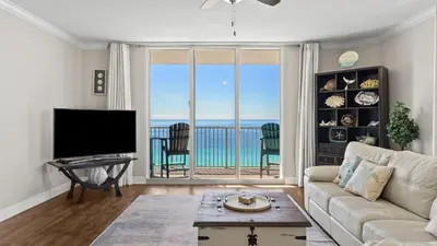 a living room with a couch and a view of the ocean at Gulf-Front PCB Condo w Balcony Resort Amenities Game Room Pools Beach Gear Tortuga 1301 by AvantStay in Panama City Beach