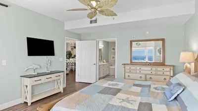 a bedroom with a bed and a sink and a television at Gulf-Front PCB Condo w Balcony Resort Amenities Game Room Pools Beach Gear Tortuga 1301 by AvantStay in Panama City Beach