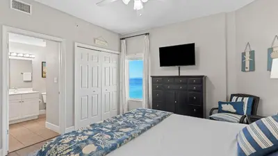 a bedroom with a bed and a bathroom with a television at Gulf-Front PCB Condo w Balcony Resort Amenities Game Room Pools Beach Gear Tortuga 1301 by AvantStay in Panama City Beach