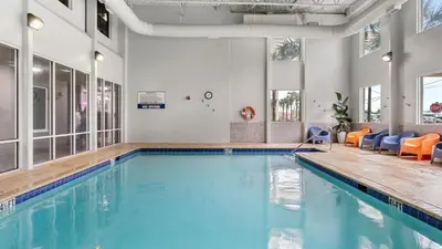 a swimming pool with blue water in a building at Gulf-Front PCB Condo w Balcony Resort Amenities Game Room Pools Beach Gear Tortuga 1301 by AvantStay in Panama City Beach