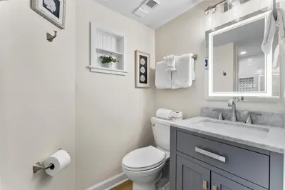 a white bathroom with a toilet and a sink at Sunshine at PP A-914 in Panama City Beach