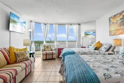 a living room with a bed and a couch at Beachfront Studio with Pool & Gulf Views! by Dolce Vita Getaways PCB in Panama City Beach