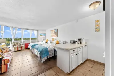 a kitchen and a bedroom with a bed and a couch at Beachfront Studio with Pool & Gulf Views! by Dolce Vita Getaways PCB in Panama City Beach