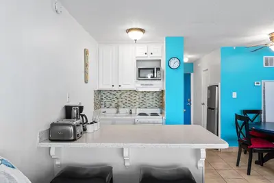 a kitchen with white cabinets and a counter top at Beachfront Studio with Pool & Gulf Views! by Dolce Vita Getaways PCB in Panama City Beach
