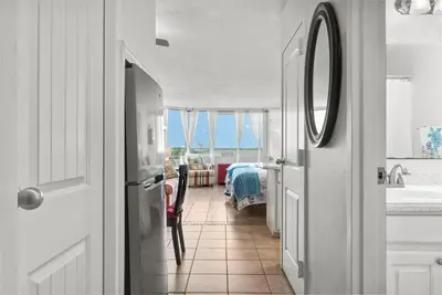 a hallway with a bathroom with a sink and a mirror at Beachfront Studio with Pool & Gulf Views! by Dolce Vita Getaways PCB in Panama City Beach