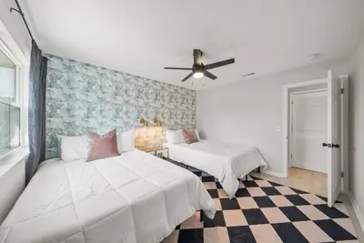 a bedroom with two beds and a ceiling fan at Disco Dolphin – Your Funky Beachside Haven in PCB in Panama City Beach