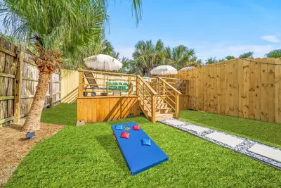 a playground in a backyard with a wooden fence at Disco Dolphin – Your Funky Beachside Haven in PCB in Panama City Beach