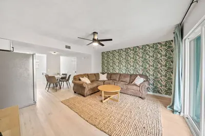 a living room with a couch and a table at Pool + Games + Outdoor Dining + Walk to the Beach in Panama City Beach
