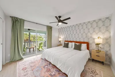 a bedroom with a large bed with a ceiling fan at Pool + Games + Outdoor Dining + Walk to the Beach in Panama City Beach