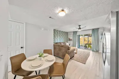 a living room with a table and chairs and a couch at Pool + Games + Outdoor Dining + Walk to the Beach in Panama City Beach