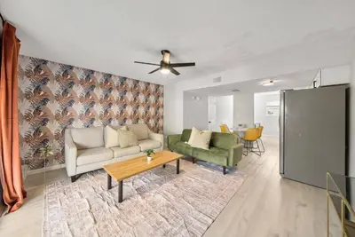 a living room with a couch and a table at Disco Dolphin Compound | 2x PCB Private Retreats! in Panama City Beach