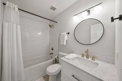 a white bathroom with a sink and a mirror at Disco Dolphin Compound | 2x PCB Private Retreats! in Panama City Beach