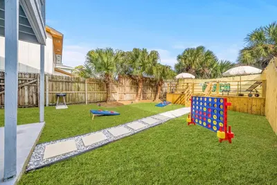 a backyard with a play yard with a playground at Disco Dolphin Compound | 2x PCB Private Retreats! in Panama City Beach