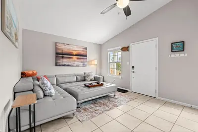 a living room with a couch and a ceiling fan at Sunset Retreat TOO - 2BR - 4 Min Walk to Beach in Panama City Beach