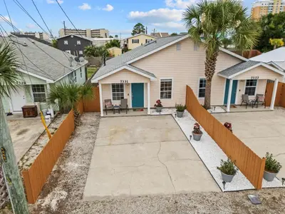 a house with a driveway and palm trees at 4 Min Walk to Sand - 2BR - King Bed - Private Yard in Panama City Beach