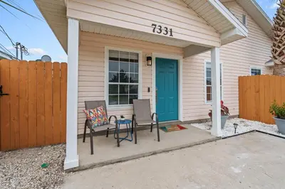a house with two chairs and a blue door at 4 Min Walk to Sand - 2BR - King Bed - Private Yard in Panama City Beach