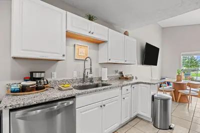 a kitchen with white cabinets and a sink at 4 Min Walk to Sand - 2BR - King Bed - Private Yard in Panama City Beach