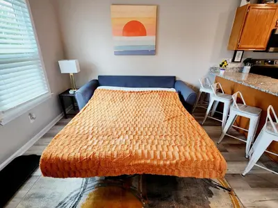 a living room with a bed and a kitchen at Sunset Dreams TOO - King Bed - 5 Min Walk to Beach in Panama City Beach