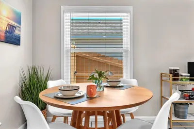 a dining room with a wooden table and white chairs at Sunset Dreams TOO - King Bed - 5 Min Walk to Beach in Panama City Beach