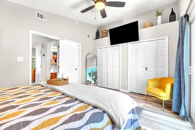 a bedroom with a bed and a flat screen tv at Sunset Dreams TOO - King Bed - 5 Min Walk to Beach in Panama City Beach
