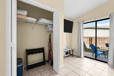 a room with a room with bunk beds and a patio at 5 Min Walk to Sand - King Bed - Private Yard in Panama City Beach