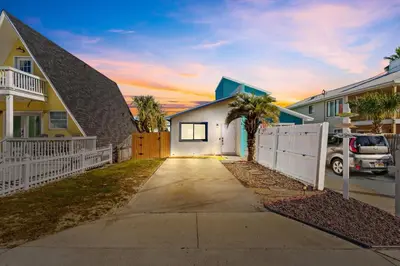a driveway leading to a house with a white fence at 5 Min Walk to Sand - King Bed - Private Yard in Panama City Beach