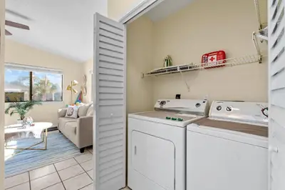 a kitchen and living room with a washer and dryer at The Sand Dollar - King Bed - 6 Min Walk to Beach in Panama City Beach