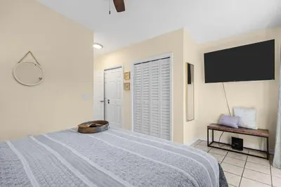 a bedroom with a bed and a flat screen tv at The Sand Dollar - King Bed - 6 Min Walk to Beach in Panama City Beach