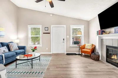 a living room with a blue couch and a fireplace at Sunset Dreams - King Bed - 5 Min Walk to Beach in Panama City Beach