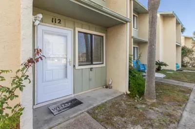 a white door of a house with a palm tree at Family Ready 3BR 2.5BA Home, Near Parks, Shops And Beach in Panama City Beach